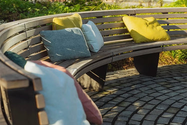 hum outdoorkissen draußen auf einer Bank im Garten