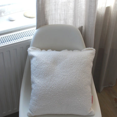 hum kissen in weiß auf einem stuhl